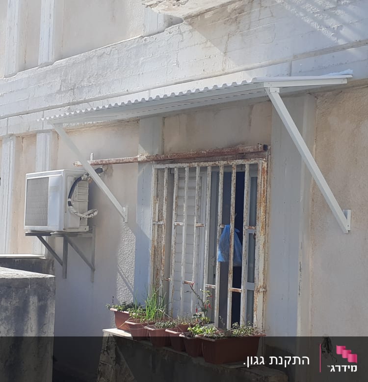 סוכך אלומיניום מעל חלון עם סורגים